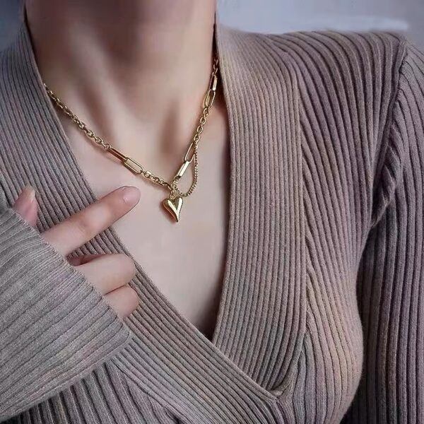 a gold heart necklace on a white surface