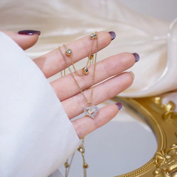a hand with a chain necklace on it