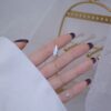 a hand with a gold Necklace diamond ring