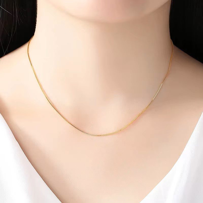 a person wearing a gold chain necklace